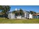The backyard features an enclosed patio and well manicured lawn, complete with swaying palm trees at 18412 Oriole St, Lutz, FL 33558