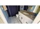 The renovated bathroom features a granite countertop, modern hardware, and a blue shower curtain at 18412 Oriole St, Lutz, FL 33558