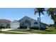 Charming one-story home features a well-manicured lawn, mature palm trees and a two-car garage in a tranquil setting at 18412 Oriole St, Lutz, FL 33558
