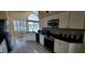 Well-lit kitchen with stainless steel appliances, white cabinets, black countertops, and tile flooring, plus a breakfast table at 18412 Oriole St, Lutz, FL 33558