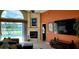 Cozy living room featuring a fireplace, neutral carpet, and sliding glass doors with views of the outdoor pool at 18412 Oriole St, Lutz, FL 33558