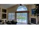 Bright living room with high vaulted ceilings, carpet, fireplace, and sliding glass doors to the outdoor pool at 18412 Oriole St, Lutz, FL 33558