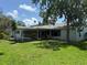 Spacious backyard featuring a well-manicured lawn, screened-in porch, and mature trees at 1894 Union St, Clearwater, FL 33763