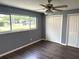 This bedroom has gray walls, wood floors, a ceiling fan, and an expansive window view at 1894 Union St, Clearwater, FL 33763