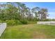 Large grassy backyard area with a white fence and wooded perimeter for privacy at 20123 Bay Cedar Ave, Tampa, FL 33647
