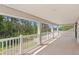 Large balcony with white railings and a view of lush trees at 20123 Bay Cedar Ave, Tampa, FL 33647