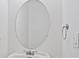 Clean half bathroom with a sink, chrome faucet, round mirror, and towel rack at 20123 Bay Cedar Ave, Tampa, FL 33647