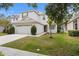 Inviting two-story home featuring a two-car garage, manicured lawn and a young palm tree at 20123 Bay Cedar Ave, Tampa, FL 33647