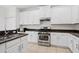 Modern kitchen featuring a stainless steel gas range, double sink, and white cabinetry at 20123 Bay Cedar Ave, Tampa, FL 33647