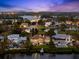 Panoramic aerial view showcases waterfront homes, lush greenery and a tranquil lake at twilight at 2081 Pointe Alexis Dr, Tarpon Springs, FL 34689