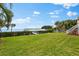 Well-maintained backyard featuring a pristine lawn, private dock, and lush tropical landscaping at 2081 Pointe Alexis Dr, Tarpon Springs, FL 34689
