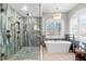 Modern bathroom featuring standalone tub, walk-in shower, and neutral color palette at 2081 Pointe Alexis Dr, Tarpon Springs, FL 34689