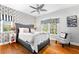 Stylish bedroom featuring hardwood floors, a patterned accent wall, and natural light from a large window at 2081 Pointe Alexis Dr, Tarpon Springs, FL 34689