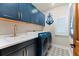 Well-equipped laundry room with blue cabinets, gold fixtures, patterned floor, and modern washer/dryer at 2081 Pointe Alexis Dr, Tarpon Springs, FL 34689