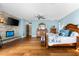 Inviting main bedroom features hardwood floors, stone accent wall with fireplace, blue walls and natural lighting at 2081 Pointe Alexis Dr, Tarpon Springs, FL 34689