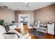 Well-lit office with hardwood floors, patterned wallpaper, and a glimpse of a living area through an open doorway at 2081 Pointe Alexis Dr, Tarpon Springs, FL 34689