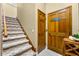 Staircase featuring patterned carpeting, wooden handrail, and two wooden doors at 2081 Pointe Alexis Dr, Tarpon Springs, FL 34689