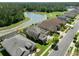Aerial view of homes with screened enclosures and a lake with manicured lawns at 27318 Sora Blvd, Wesley Chapel, FL 33544