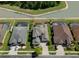 Aerial view of the home with a screened pool, mature landscaping and brick paver driveway at 27318 Sora Blvd, Wesley Chapel, FL 33544