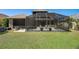 Backyard with a large, screened enclosure over a patio furnished with outdoor furniture at 27318 Sora Blvd, Wesley Chapel, FL 33544