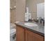 Bathroom features a wooden vanity with stone countertop, sink, and toilet at 27318 Sora Blvd, Wesley Chapel, FL 33544