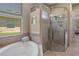 Bright bathroom featuring a soaking tub next to a large glass enclosed shower at 27318 Sora Blvd, Wesley Chapel, FL 33544