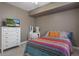 Comfortable bedroom features a TV, dresser, and colorful bedding at 27318 Sora Blvd, Wesley Chapel, FL 33544