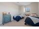 Bright bedroom featuring two twin beds and a classic turquoise-painted chest of drawers at 27318 Sora Blvd, Wesley Chapel, FL 33544