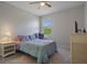 Well-lit bedroom with a cozy chair, side table, and TV stand at 27318 Sora Blvd, Wesley Chapel, FL 33544