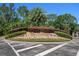 Beautiful community entrance with palm trees and landscaped sign for Quail Woods at 27318 Sora Blvd, Wesley Chapel, FL 33544