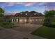 Charming two-story home with a three car garage and brick paver driveway at dusk at 27318 Sora Blvd, Wesley Chapel, FL 33544