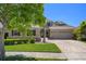 Lovely home with a manicured lawn, elegant stone accents, and a spacious three-car garage at 27318 Sora Blvd, Wesley Chapel, FL 33544