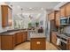 Open kitchen with stainless appliances, island, tile floors, and seamless flow into the living space at 27318 Sora Blvd, Wesley Chapel, FL 33544