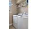 Bright laundry room with white washer, dryer and shelving for storage at 27318 Sora Blvd, Wesley Chapel, FL 33544