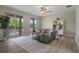 Comfortable living room with a gray couch, ceiling fan, and balcony access at 27318 Sora Blvd, Wesley Chapel, FL 33544