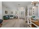 Open-concept living room with light-colored wood flooring, columns, and a staircase at 27318 Sora Blvd, Wesley Chapel, FL 33544