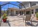 Covered patio with stone flooring, outdoor seating, and access to the backyard at 27318 Sora Blvd, Wesley Chapel, FL 33544