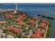 Aerial view of a waterfront community with red-tiled roofs, lush landscaping, and stunning water views at 2746 Via Tivoli # 135A, Clearwater, FL 33764