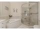 Bathroom with a corner tub, tiled shower with a glass door, and neutral-toned tiling at 2746 Via Tivoli # 135A, Clearwater, FL 33764