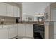 Kitchen area with granite countertops, white cabinets, and stainless steel dishwasher appliance at 2746 Via Tivoli # 135A, Clearwater, FL 33764