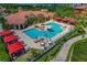 Aerial view of a luxurious pool area with cabanas, lounge chairs, and lush landscaping at 2746 Via Tivoli # 135A, Clearwater, FL 33764