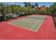Outdoor tennis court surrounded by lush greenery and palm trees, ideal for recreational play at 2746 Via Tivoli # 135A, Clearwater, FL 33764