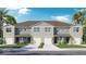 Beautiful townhome exterior with a two-car garage, neutral paint, well-kept lawn, and tropical landscaping at 31280 Paper Birch St, Wesley Chapel, FL 33545