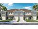 Beautiful townhome exterior with a two-car garage, neutral paint, well-kept lawn, and tropical landscaping at 31280 Paper Birch St, Wesley Chapel, FL 33545