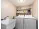Functional laundry room with utility sink, shelving, and washer/dryer at 320 Island Way # 606, Clearwater Beach, FL 33767