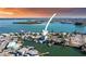Waterfront home in an ocean-side neighborhood with boat docks, lush greenery, and an island in the distance at 326 129Th E Ave, Madeira Beach, FL 33708