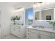 Well-lit bathroom with double sinks, white marble countertops, and modern, illuminated mirrors overlooking a water view at 326 129Th E Ave, Madeira Beach, FL 33708