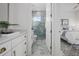 View of a bright bathroom between a bedrooom and a closet featuring gorgeous marble-styled tile in the shower at 326 129Th E Ave, Madeira Beach, FL 33708