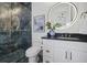 Stylish bathroom showcasing a black tile shower, modern fixtures, and an illuminated mirror above the vanity at 326 129Th E Ave, Madeira Beach, FL 33708