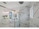 Elegant bathroom featuring a glass shower with marble tile, double vanities, and modern, illuminated mirrors at 326 129Th E Ave, Madeira Beach, FL 33708